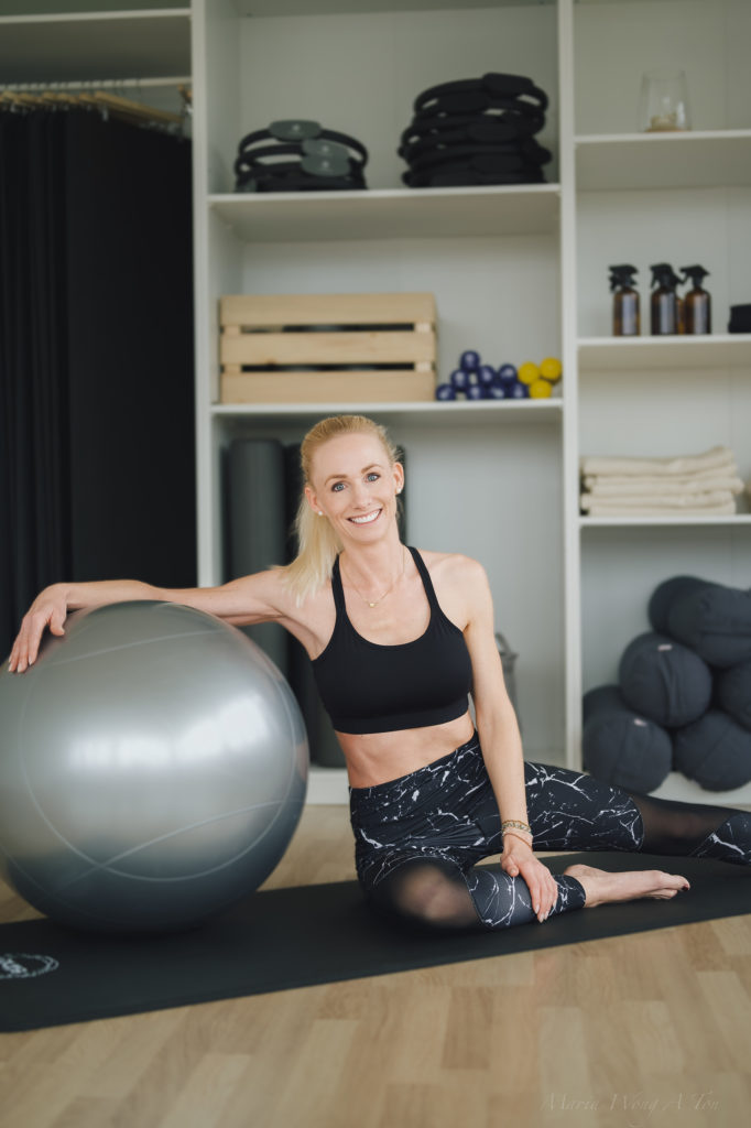 A woman dressed in a Pilates outfit performing an exercise.