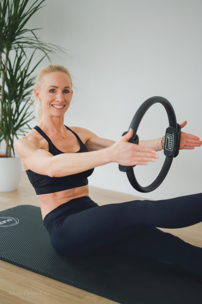 A woman dressed in a Pilates outfit performing an exercise.